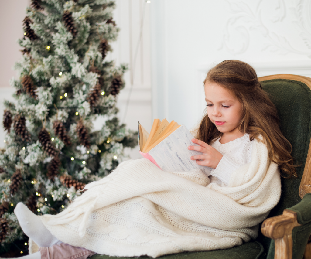 Girl Reading Christmas Picture Books by the Tree